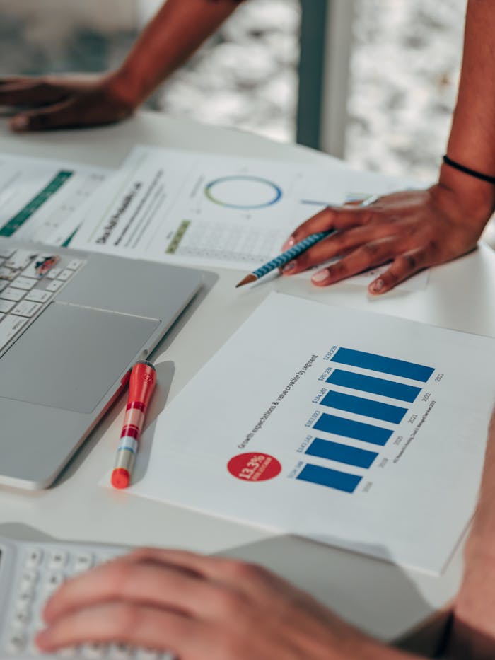 Team engaged in analyzing business data with graphs and digital devices in an office setting.